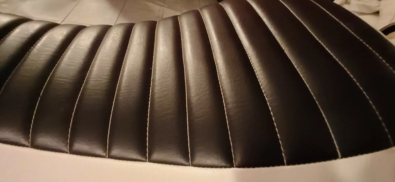 Détail des plis surpiqués d'une selle de moto restaurée